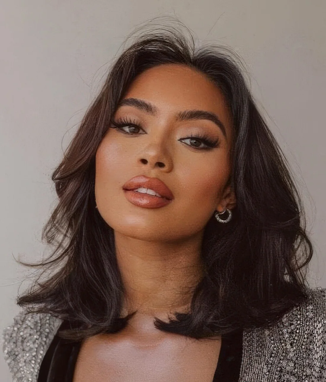 Shoulder dark brunette bob with layers, slight texture and waves and a lot of volume.