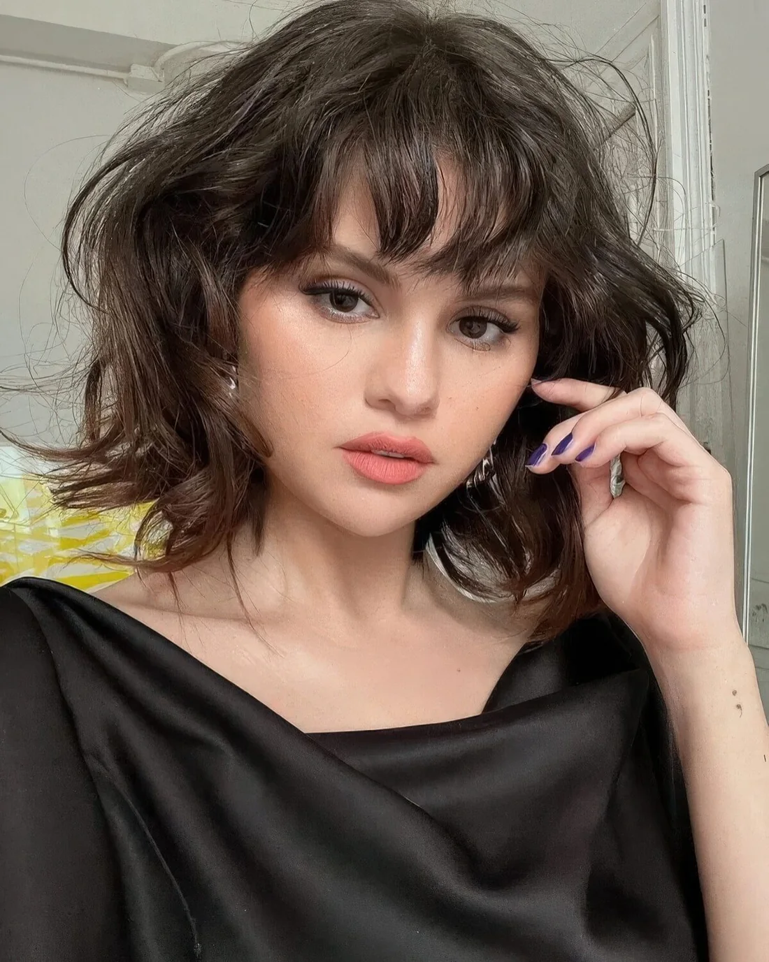 Messy and textural long bob haircut with a bit of waves, razor ends and curly wispy bangs.