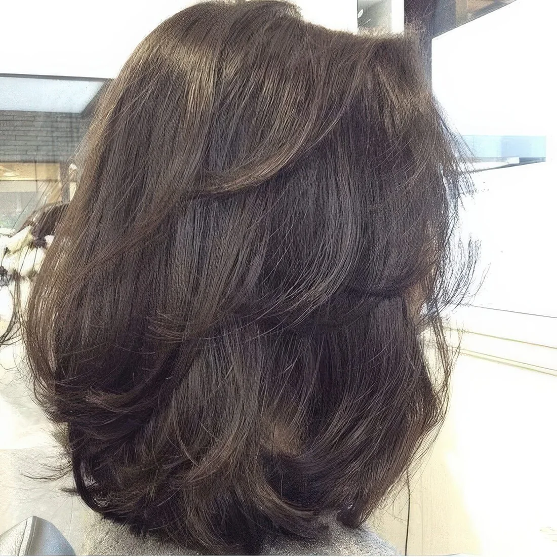 Rich brown long butterfly bob with curlend ends.