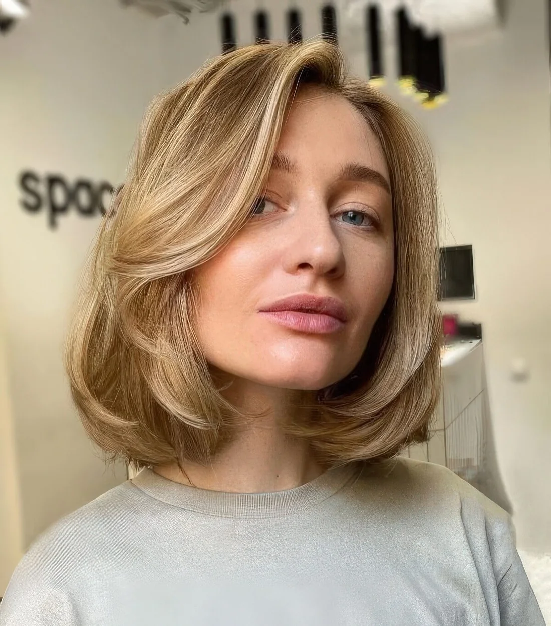 Blonde butterfly bob with hair contouring and slight waves plus some volume.
