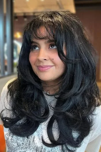 chest wavy black layers with curtain fringe shown as a butterfly haircut long hairs idea