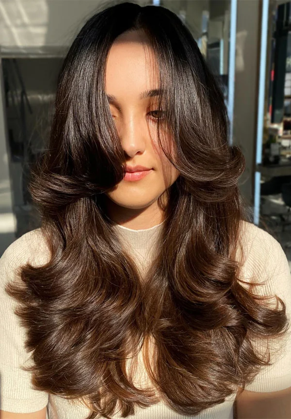 chest wavy brunette layers with curtain fringe shown as a butterfly haircut long hairs idea
