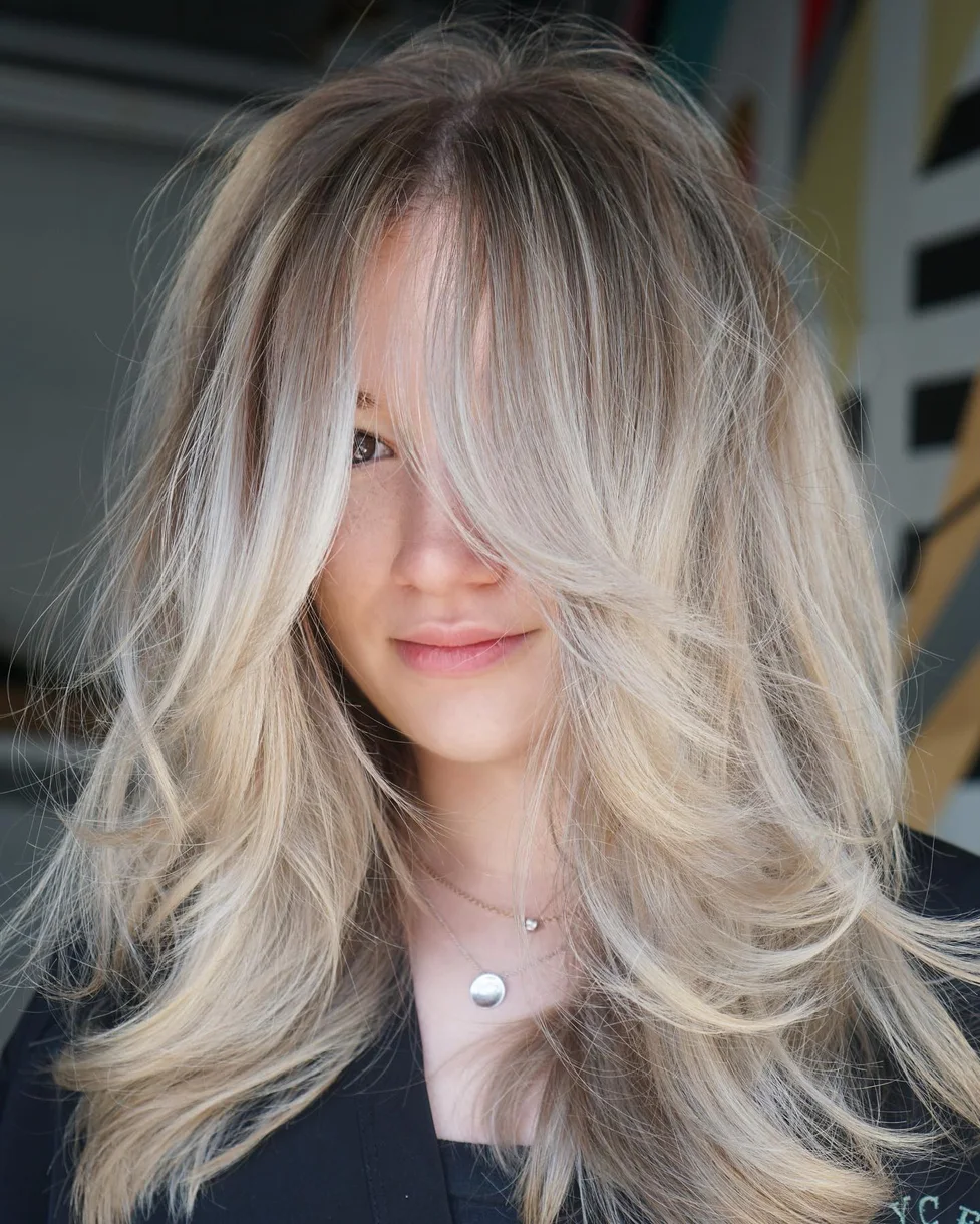 chest wavy blonde layers with curtain fringe shown as a butterfly haircut long hairs idea, featuring center part