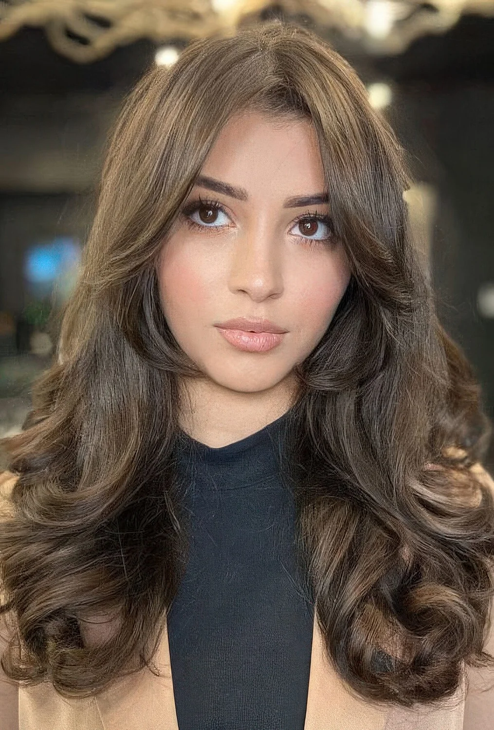 Brunette butterfly haircut with curtain bangs and curls plus volume.
