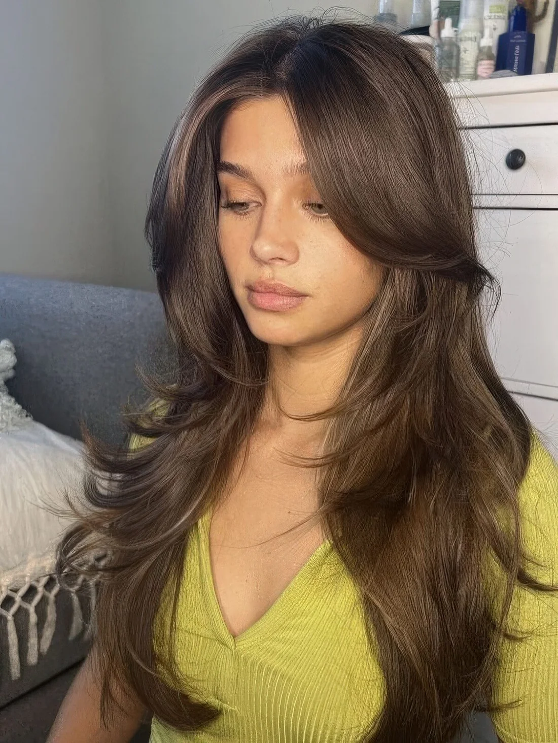 Fab brunette butterfly haircut with long curtain bangs and curled ends.
