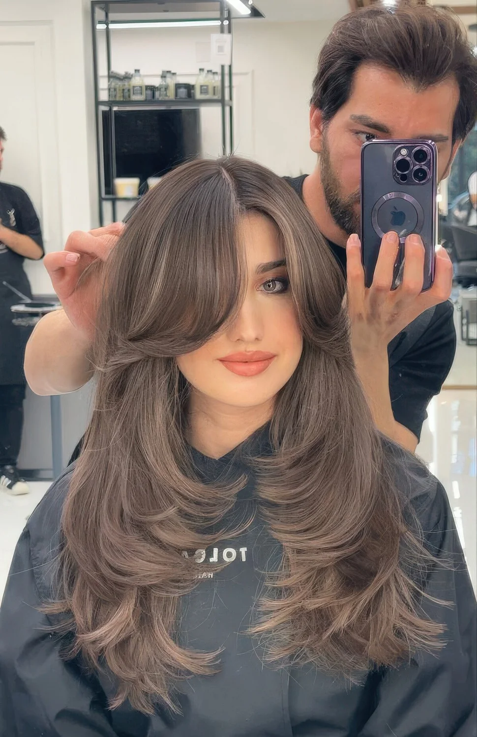 Jaw doppring long butterfly brunette hairstyle with long curtain bangs.