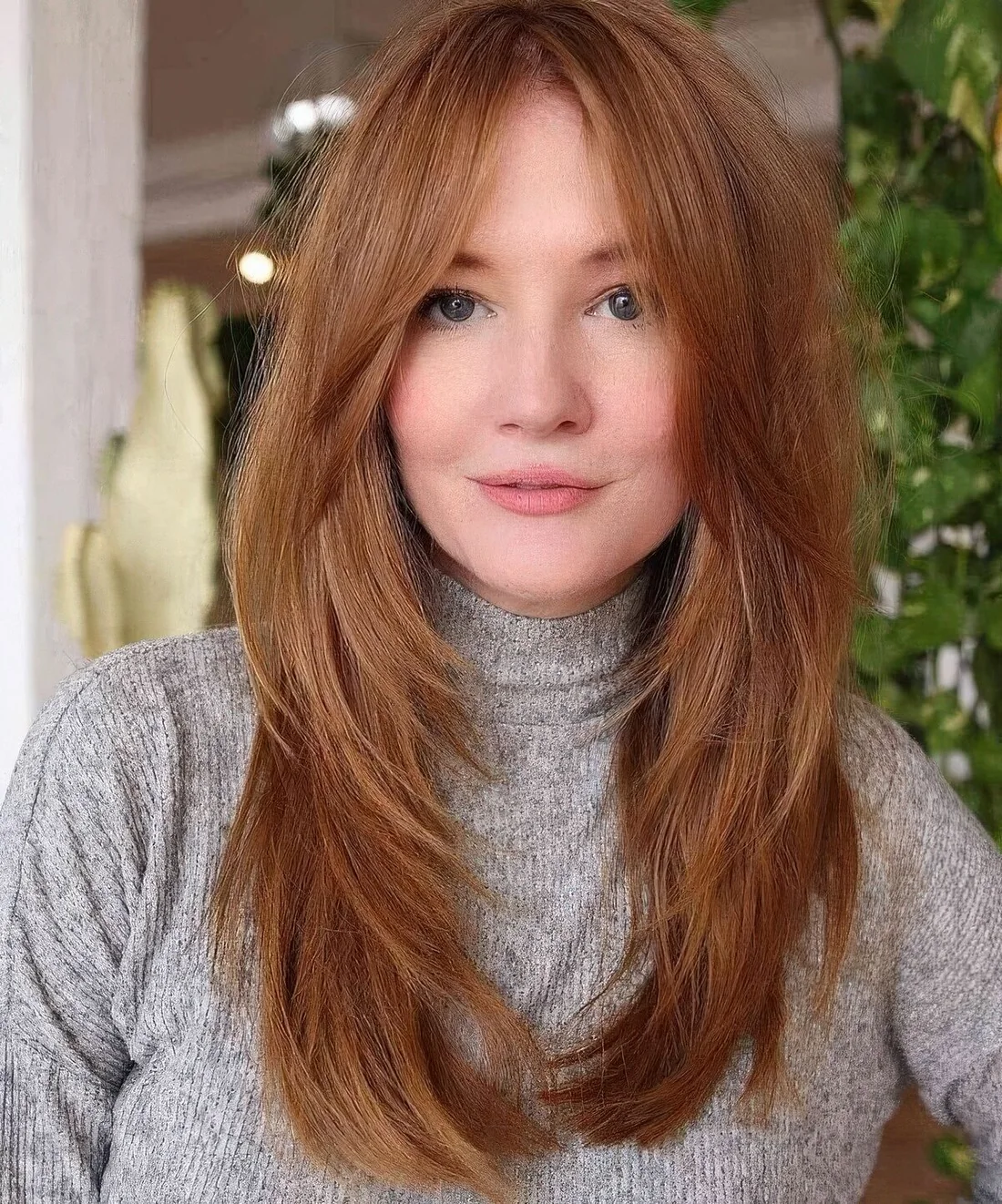 Ginger hair with a butterfly haircut, with curtain bangs.