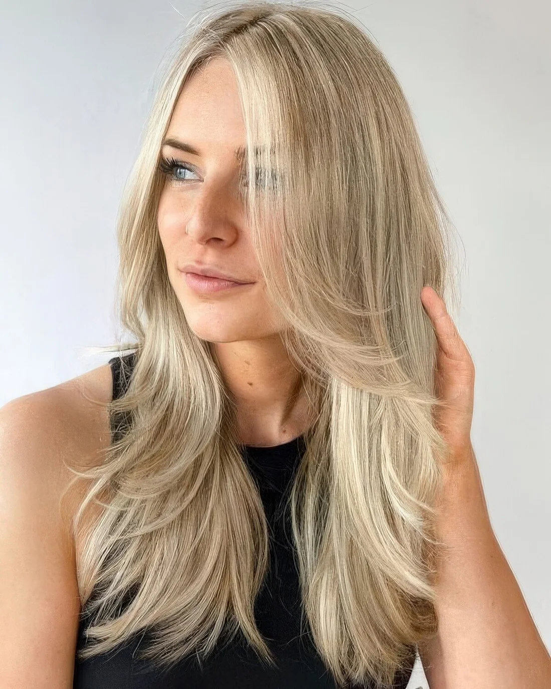 Bright blonde butterfly haircut with curved ends.