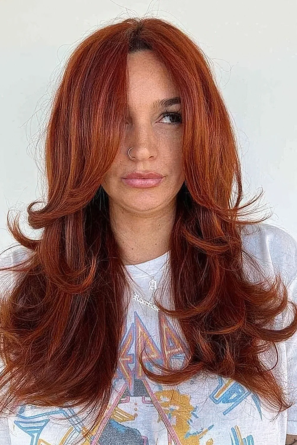 Fab red butterfly haircut on long hair, with a lot of volume, face-framing layers and curled ends.