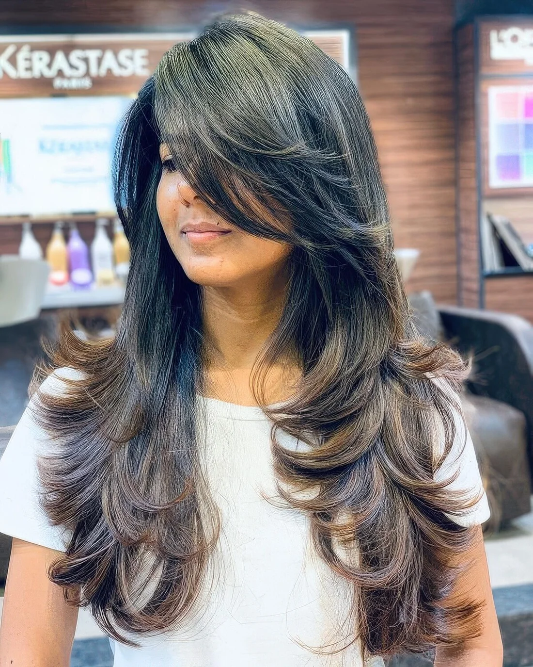Long black butterfly haircut with chestnut curled ends and side bangs plus a lot of volume.