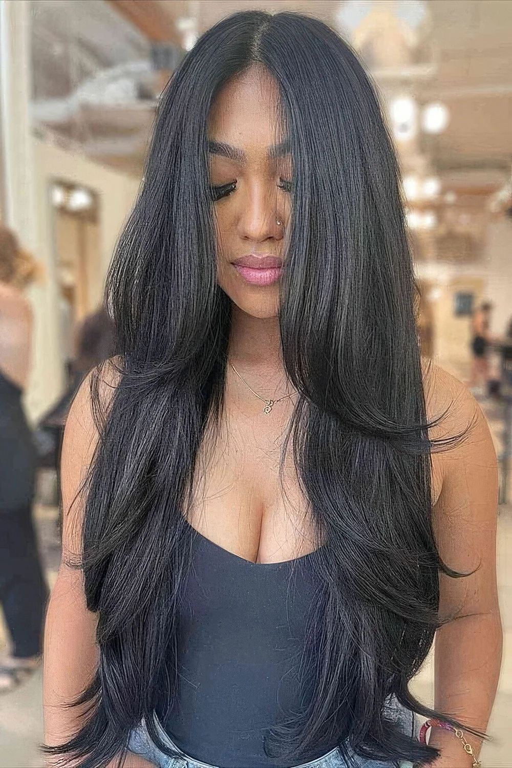 Long black butterfly haircut with curled ends and volume.