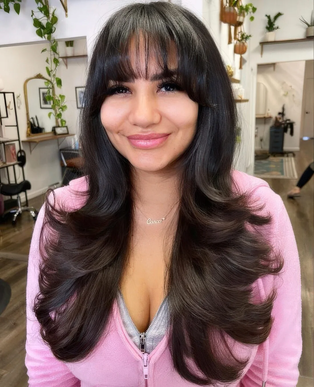 Long black butterfly haircut with wispy bangs and curled ends plus a bit of balayage for a more catchy look.