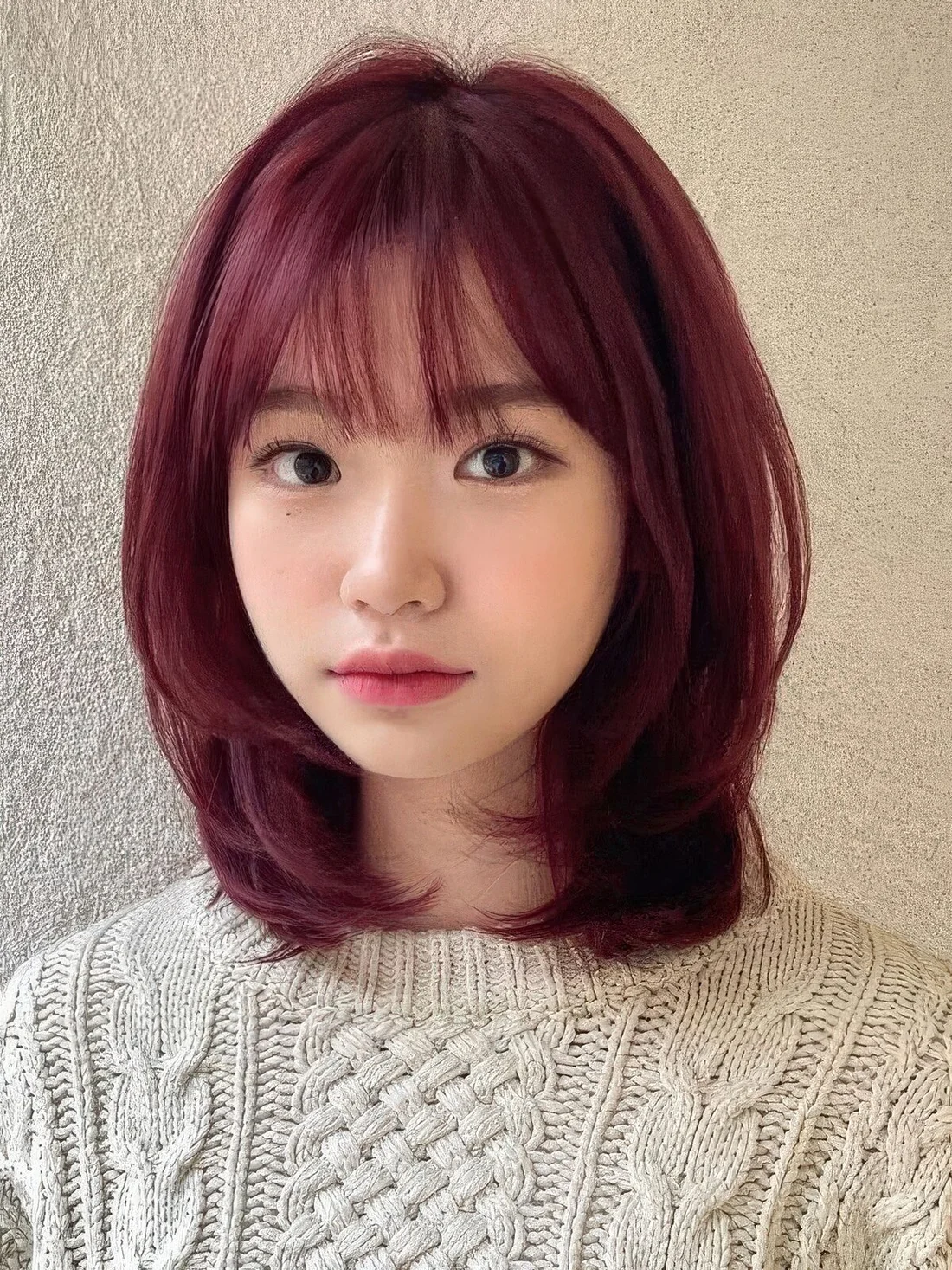 Medium-length purple butterfly haircut with wispy bangs and curled ends.
