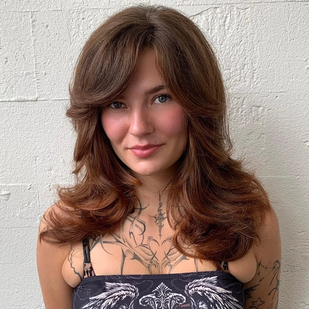 long wavy copper layers with curtain fringe shown as a butterfly haircuts with bangs idea