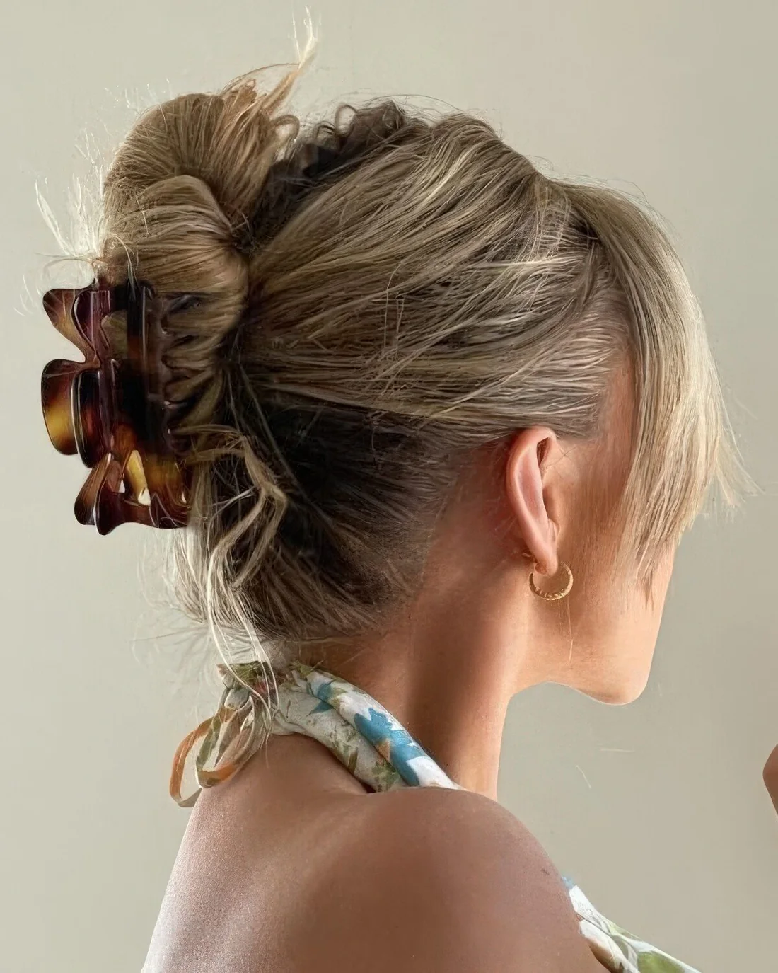 Updo with a messy volume on top and twisted hair, some bangs and a hair clip to secure the hair.