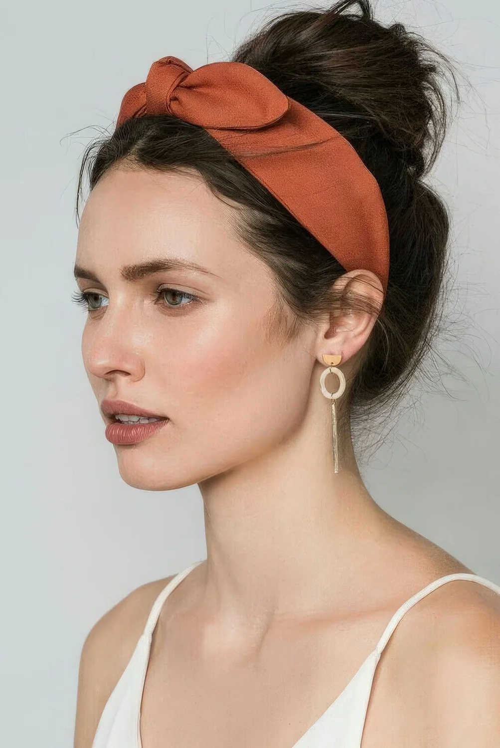 Messy ballerina top knot plus a rust colored headband to keep the hair off the face are a lovely retro combo.
