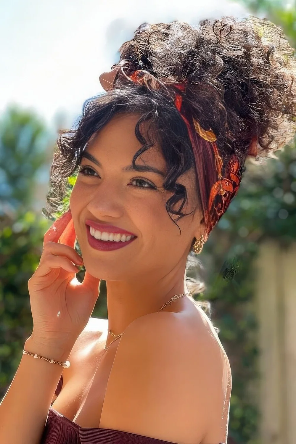 Curly top knot hairstyle with a headband.