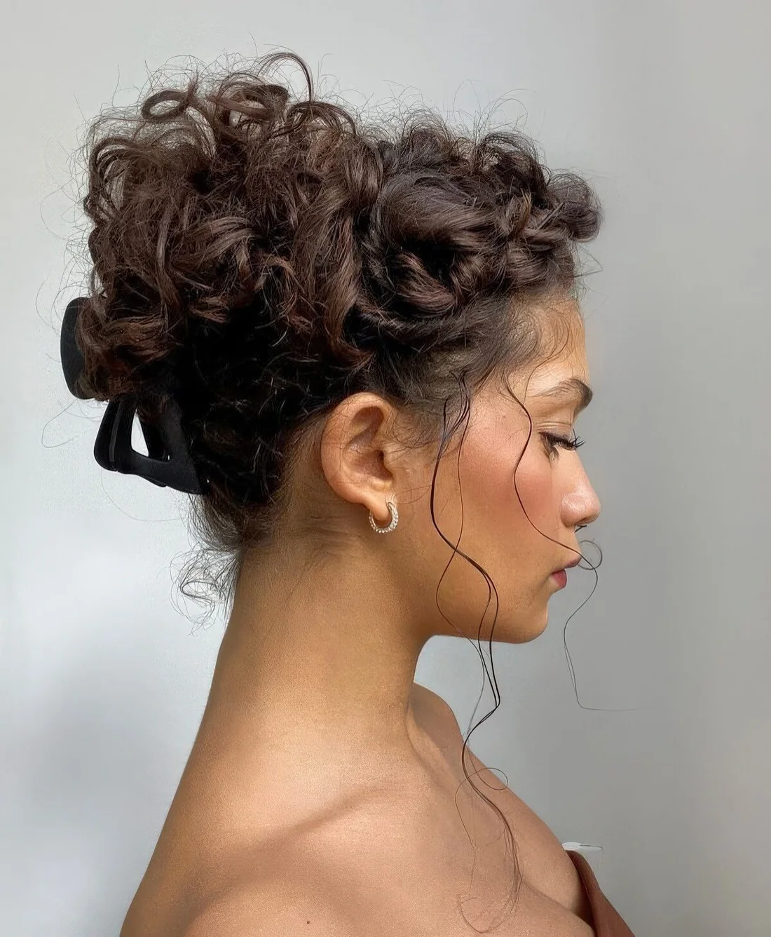 Messy curly updo with a curly top and a hair clip that.
