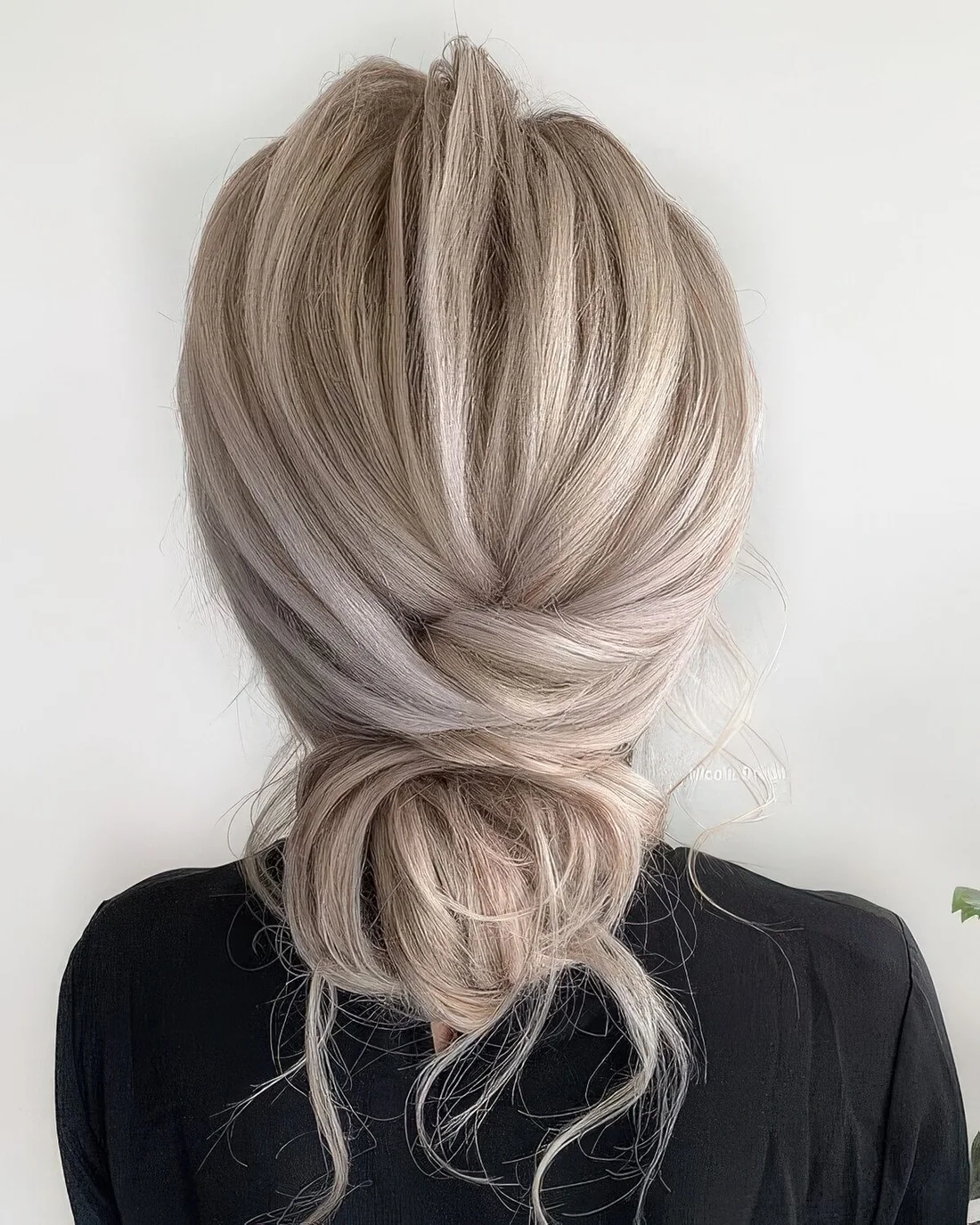 Messy low bun with a volumetric and messy top and some hair down.