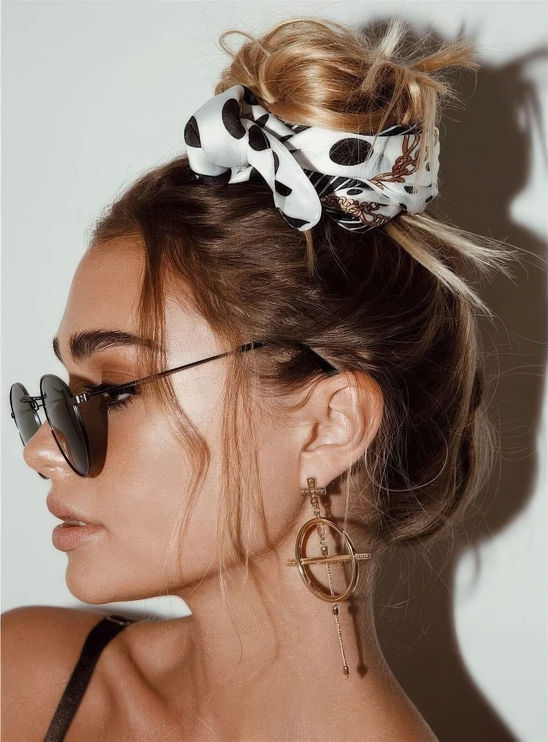 Messy top knot, a messy top, face-framing bangs and a polka dot scarf on top the knot for a pretty accent.