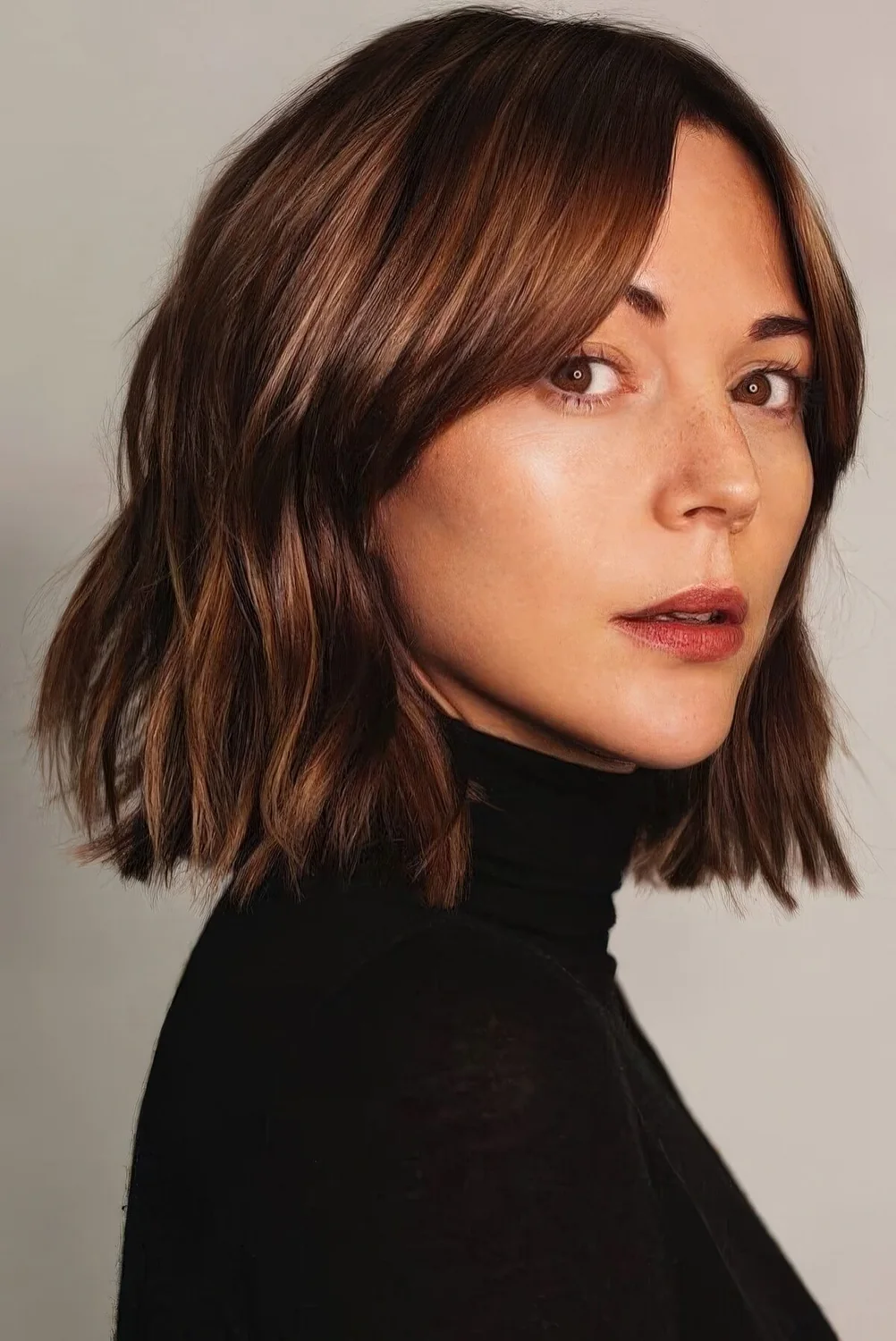 Long chestnut bob with slight waves and volume.