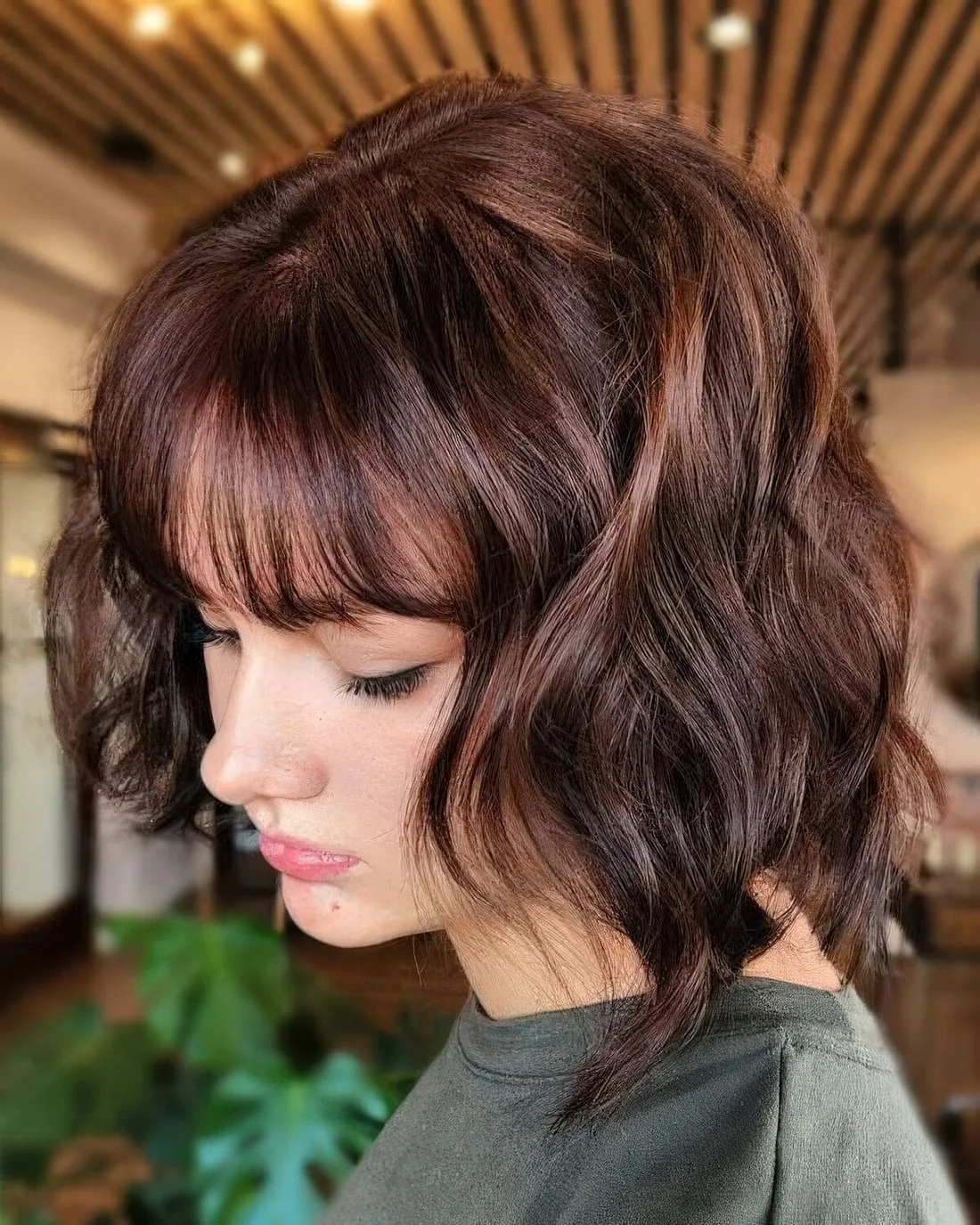 Midi wavy chestnut brown bob with bangs.