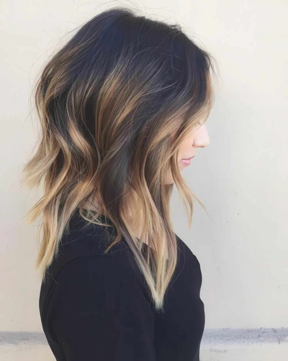 Black layered hair with caramel balayage.