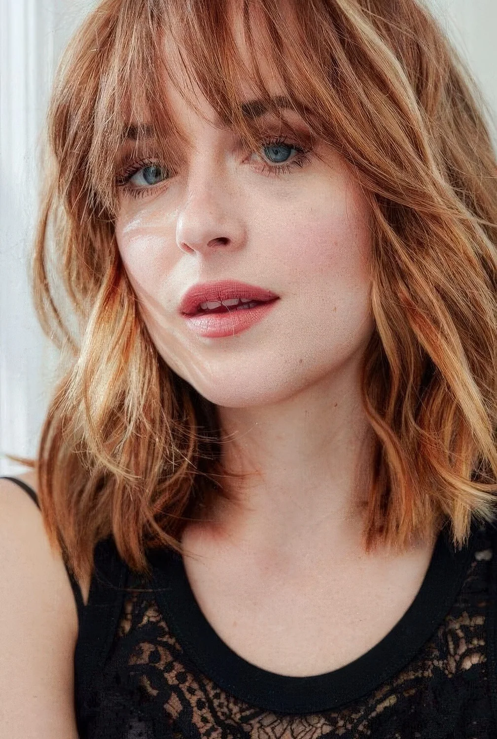 Ginger outgrown textured bob with blonde highlights and outgrown wispy bangs.