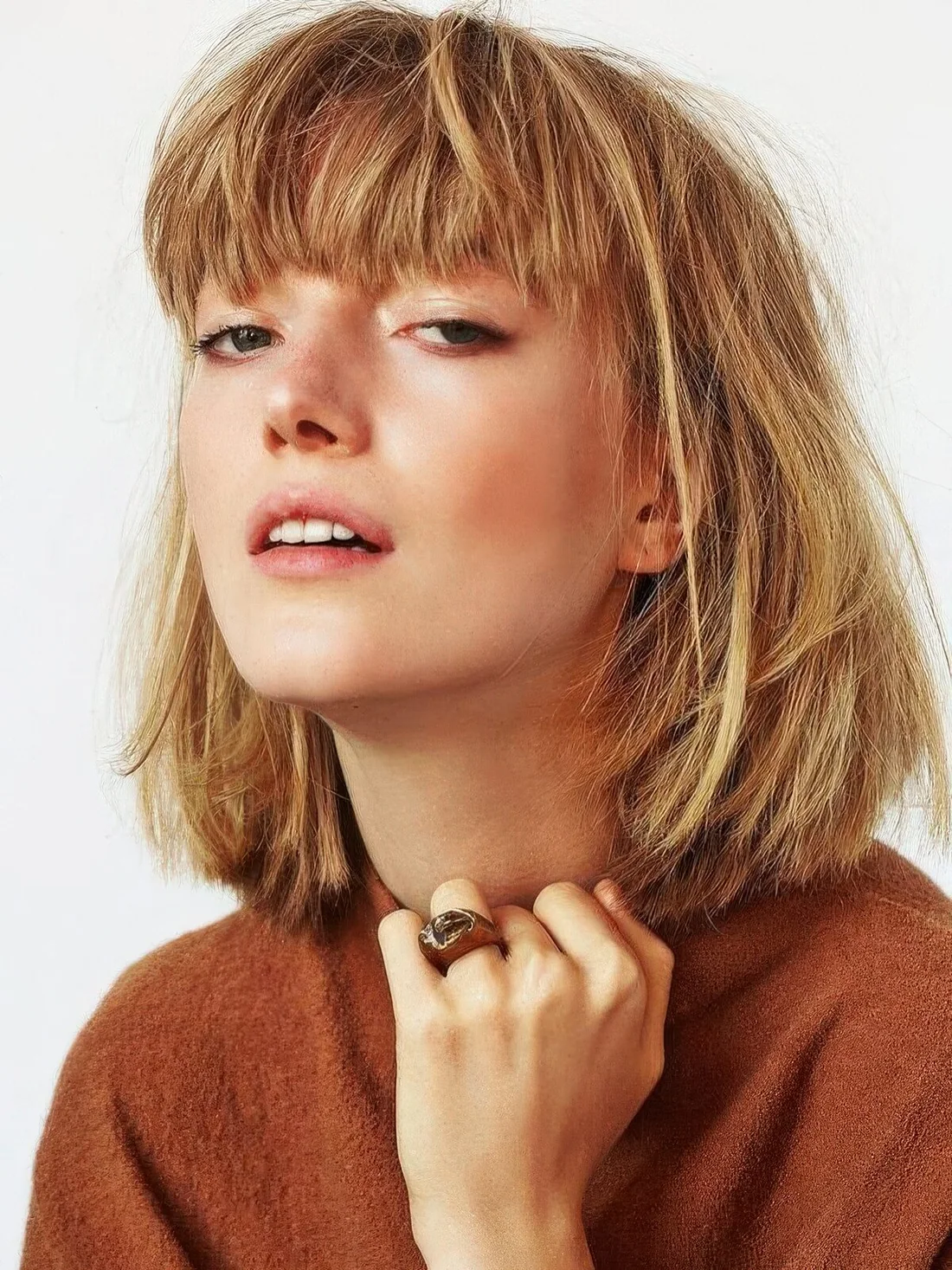 Ginger to blonde long bob with a thick fringe and a lot of volume.