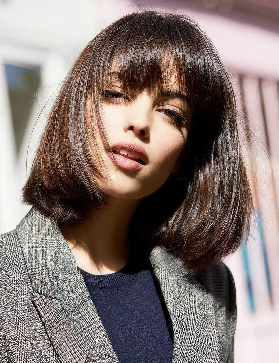 Shiny dark brown long bob with a classic fringe, with a lot of volume and curved ends.