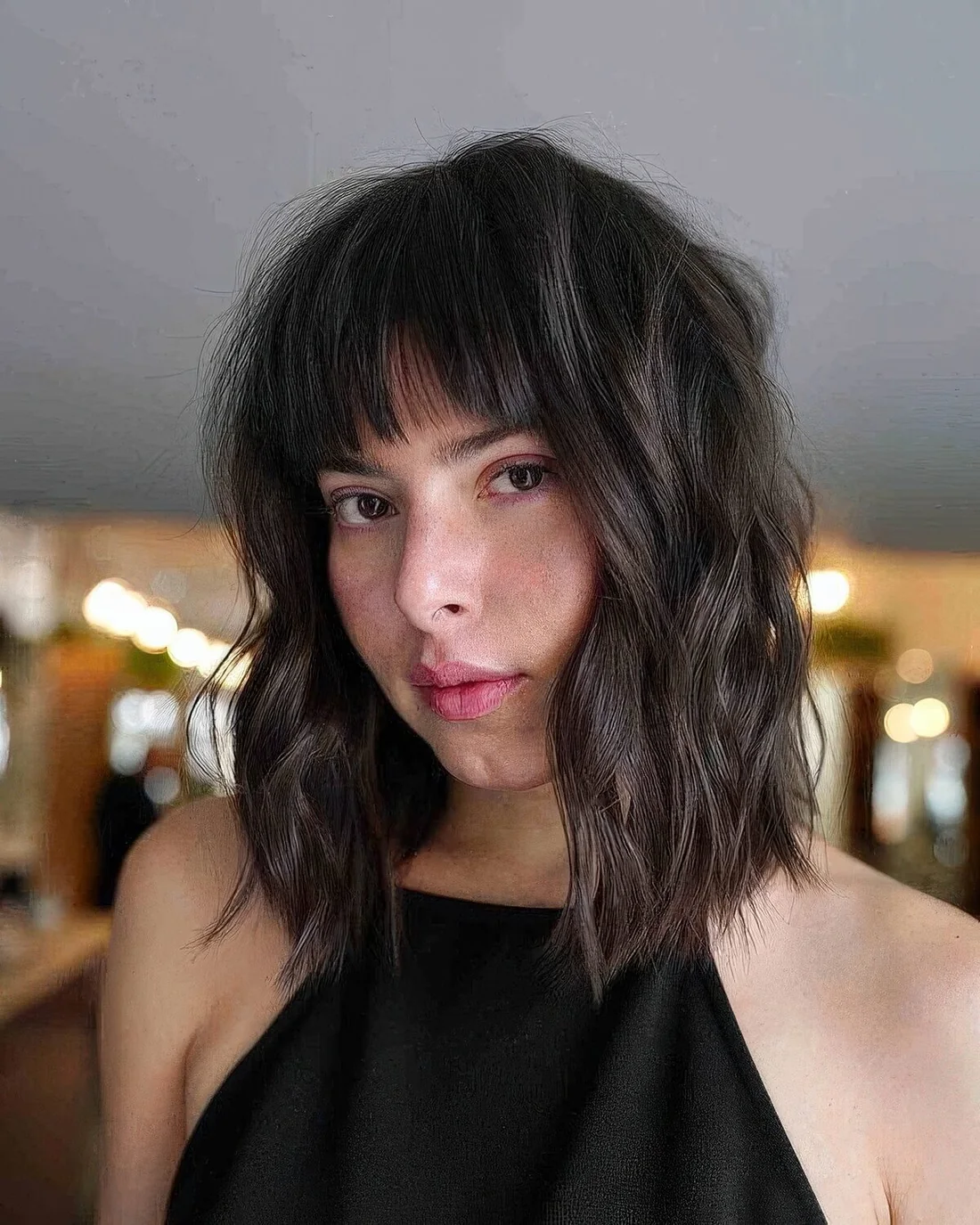 Dark brown long bob with a classic blunt fringe and waves.