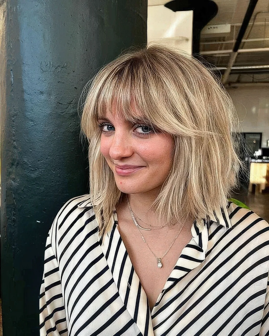 Ab londe long bob with wispy bangs and messy texture.