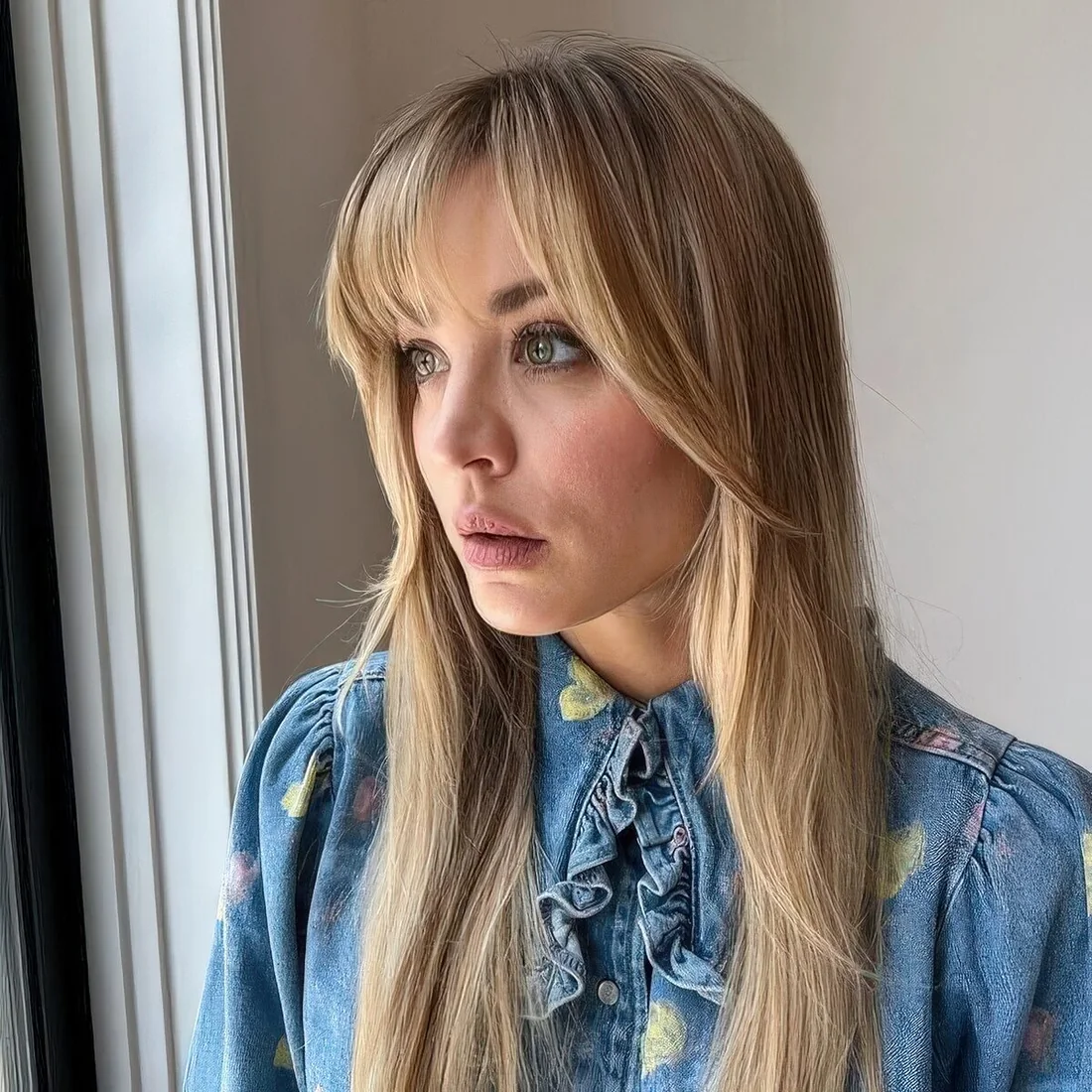 Long blonde hair with layered bangs chin-length and wispy shorter ones.