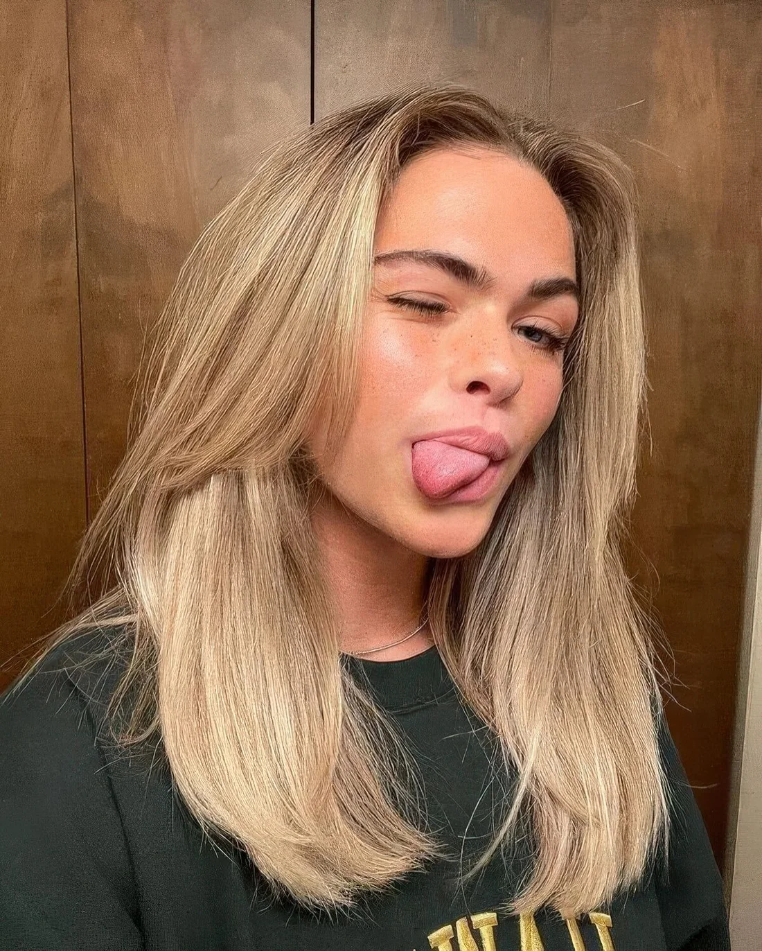 Medium-length blonde hair with chin-length bangs and middle part.