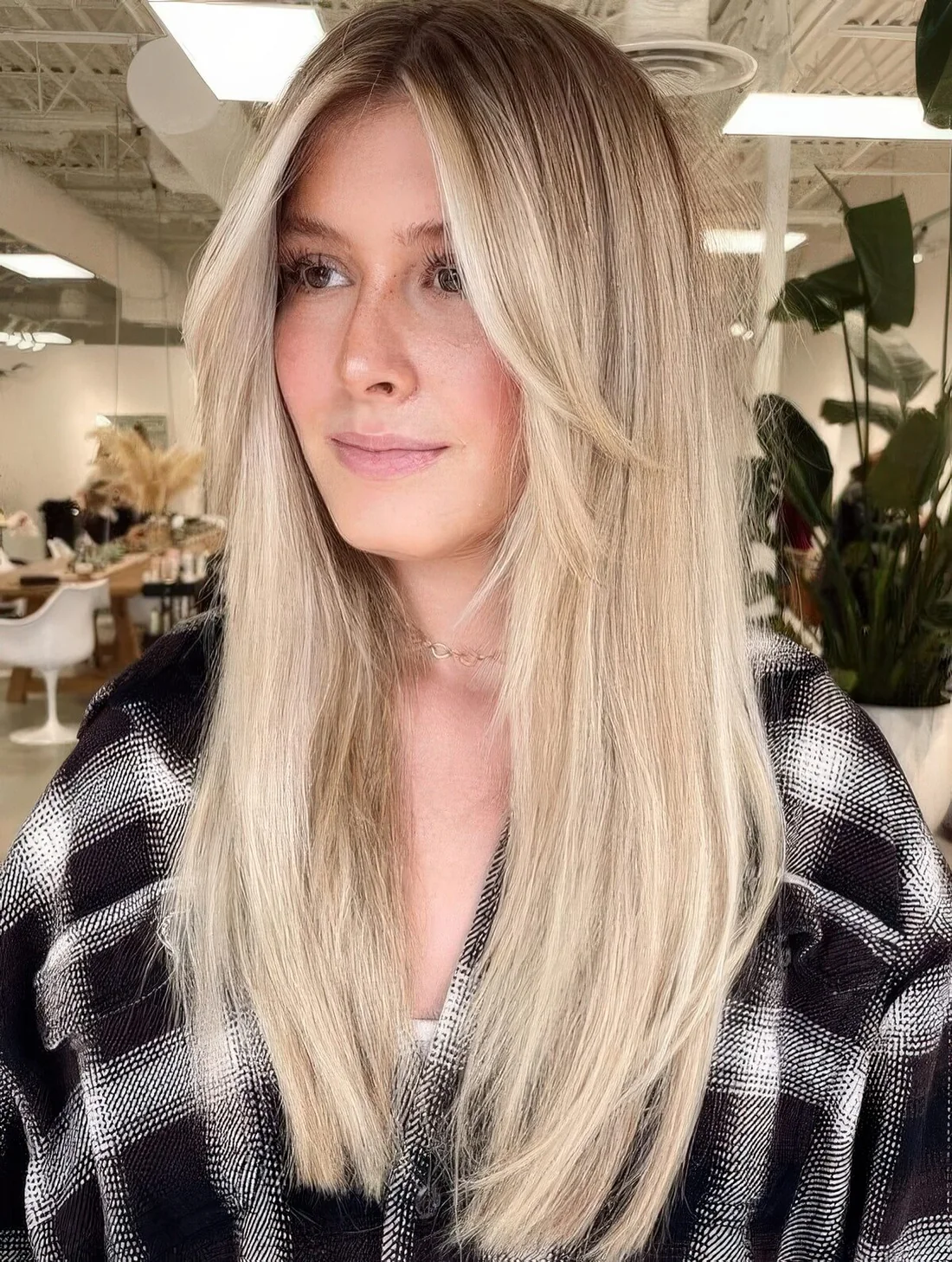 Long blonde hair with long curtain bangs.