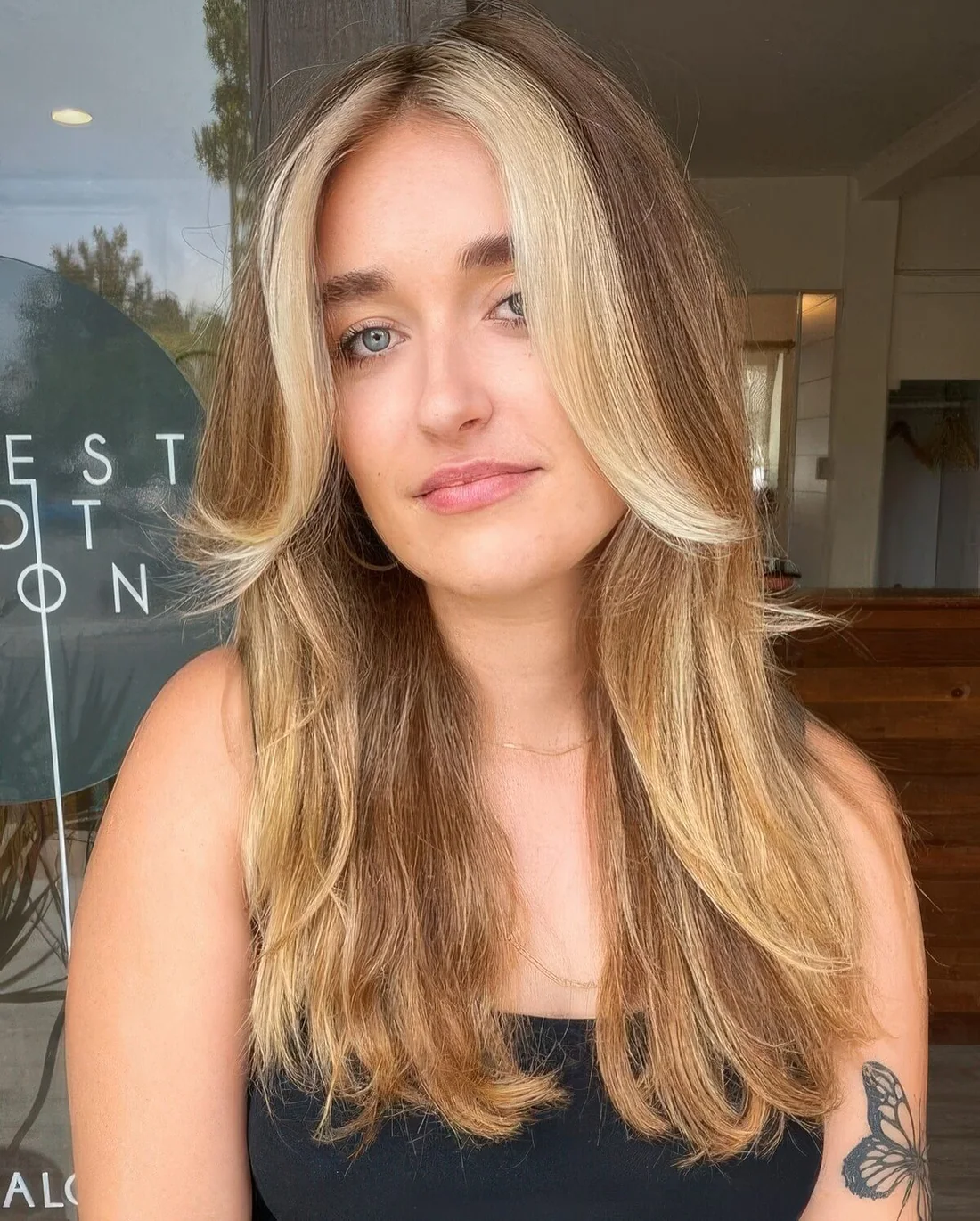 Long light brown hair with blonde highlights and a chunky chin-length money piece.
