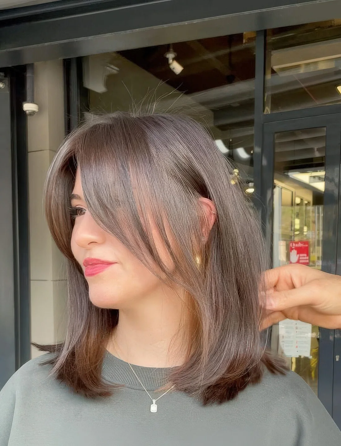 Rich brown medium-length hair with chin-length bangs, with a healthy shine.