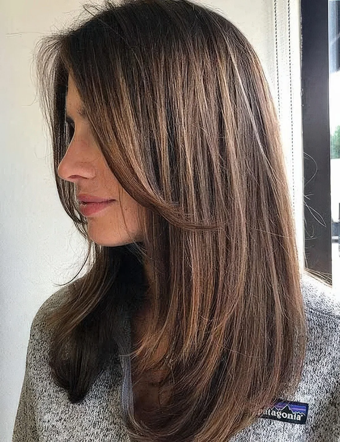 Medium-length brunette hair with a bit of layers and chin bangs.