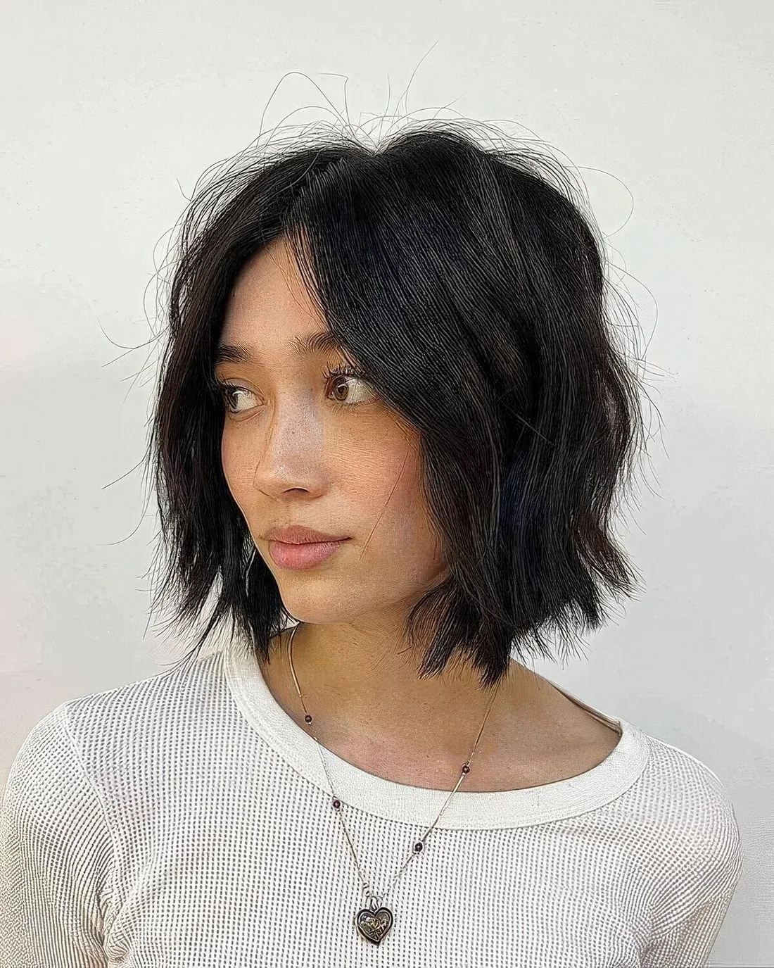 Black choppy bob with center part and waves.