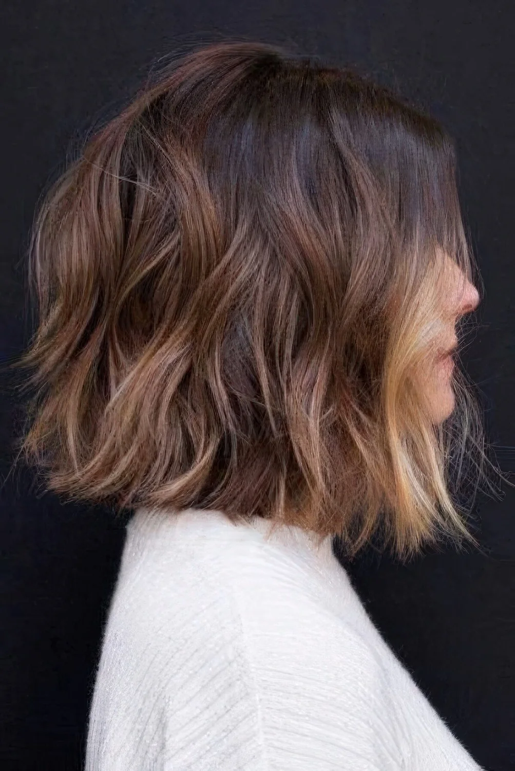 Brown choppy bob with caramel highlights and blonde face-framing locks and aves.