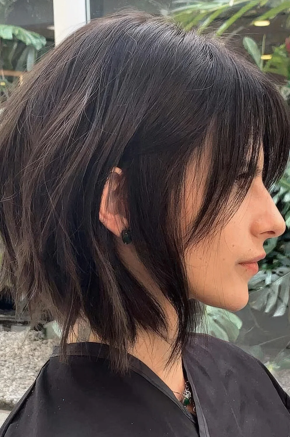 Choppy dark brunette bob with bangs and slight waves.