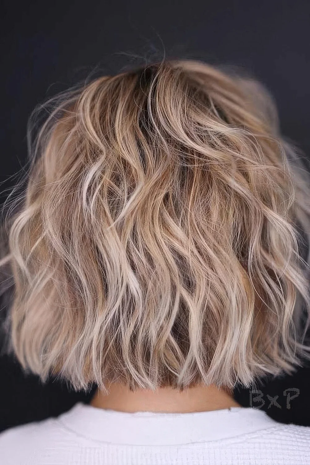 Blonde balayage choppy bob with waves.