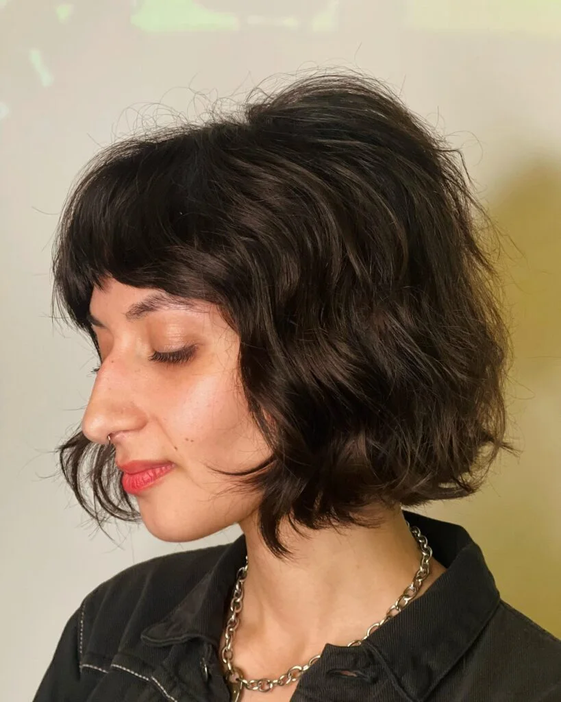 chin wavy black bob with side swept fringe shown as a choppy bob hairstyles for fine hair idea