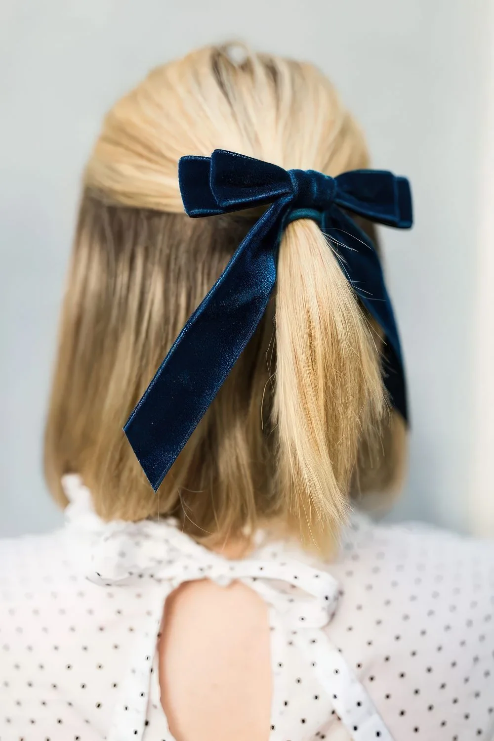 Photo showing navy velvet bow, with the hairstyle clearly visible.