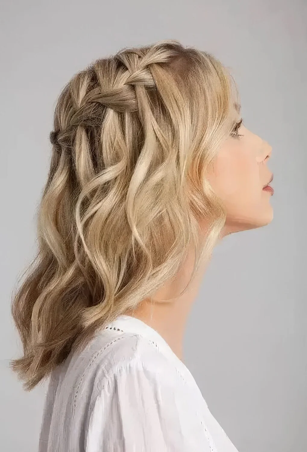 Blonde medium-length half updo with a braided top and waves down.