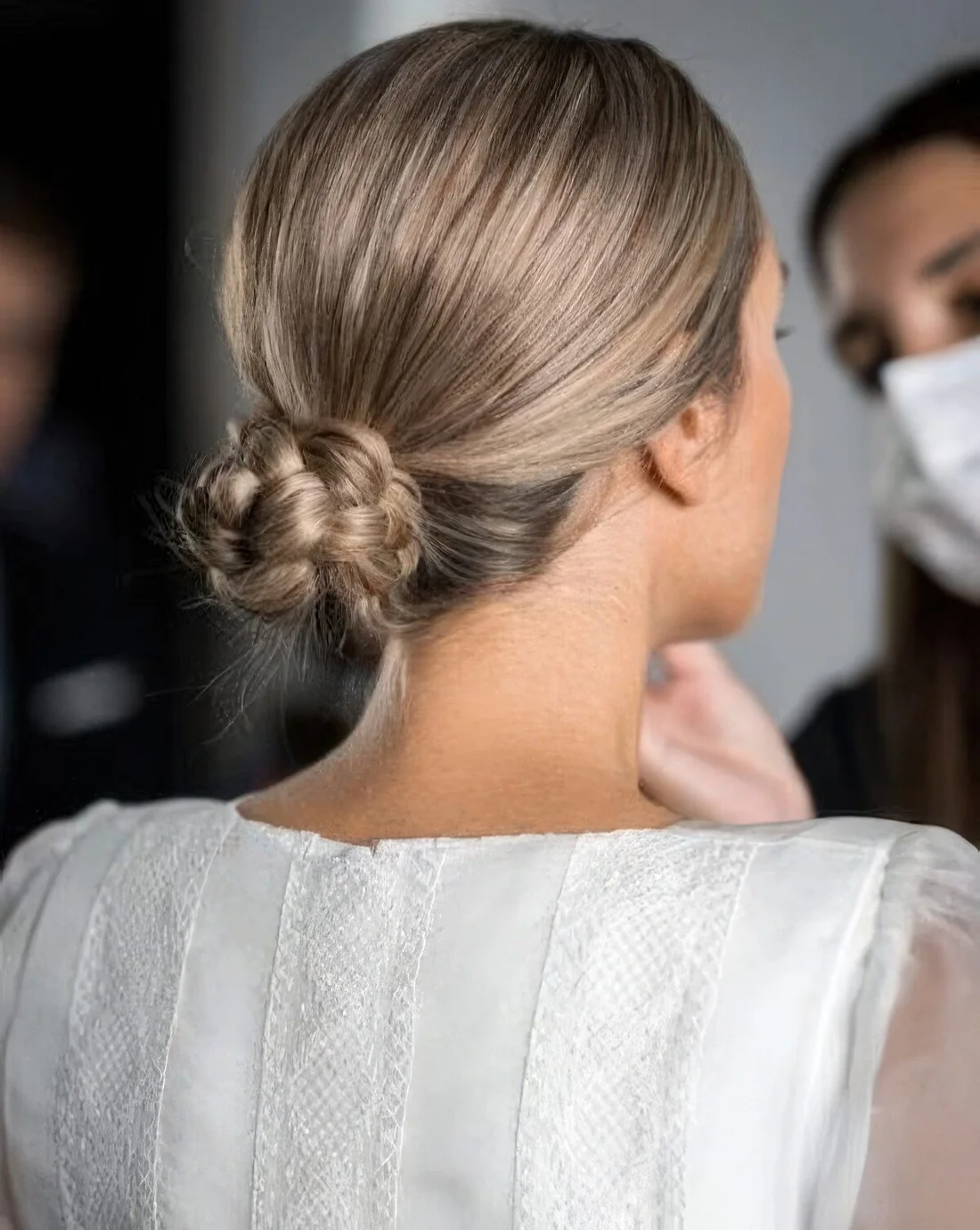 Photo showing braided low bun with a sleek top, with the hairstyle clearly visible.