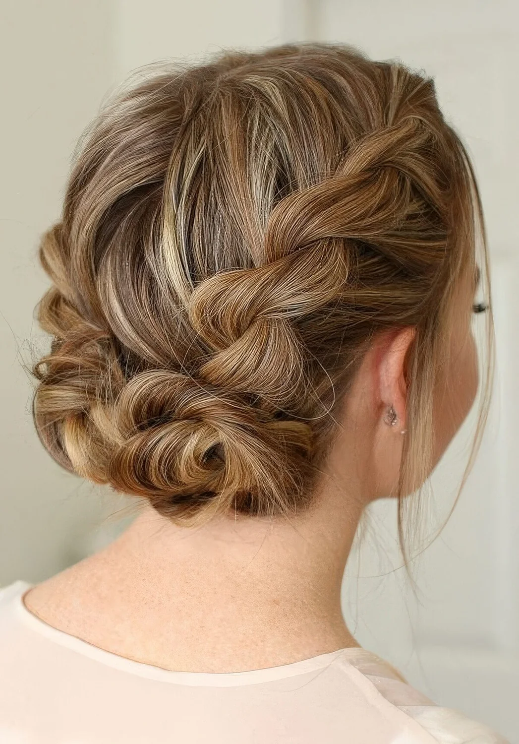 Braided updo with two twisted low buns and volume on top.