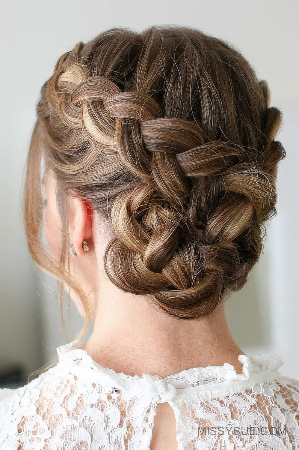 Dutch braided bun with a bump on top and face-framing hair.