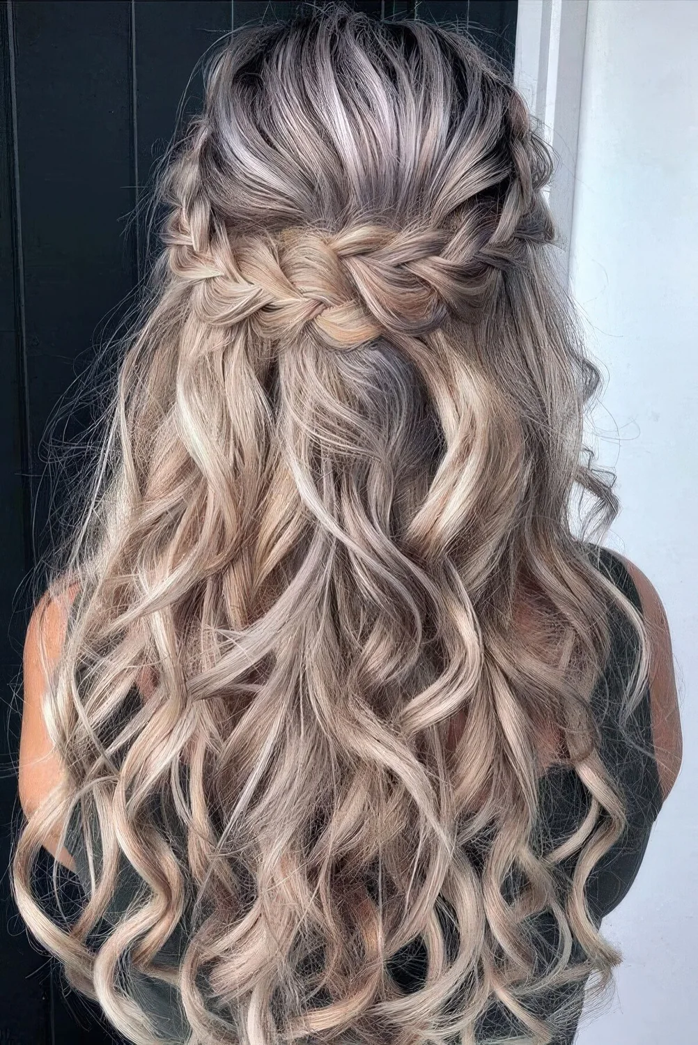 Half updo with a braided halo and waves down.