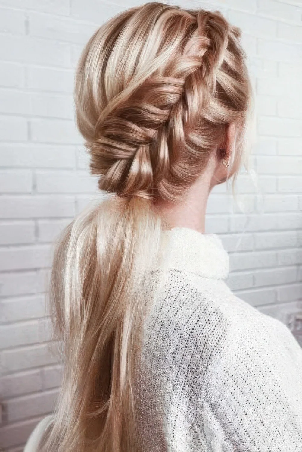 Low ponytail with a large side braid on top and a bump.
